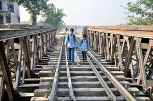 Students crossing the Piran Ghaib Railway Bridge in a dangerous way may cause any mishap.