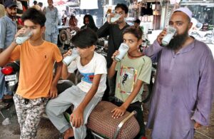 Volunteers giving water to people in a heat wave camp during scorching hot weather in the city.