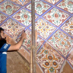 An artisan busy in glass cut work on the wall of historical Maryam masjid.
