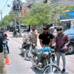 Police personnel checking motorcyclists during snap checking and take strict security in city on the occasion of Youm e Takbeer