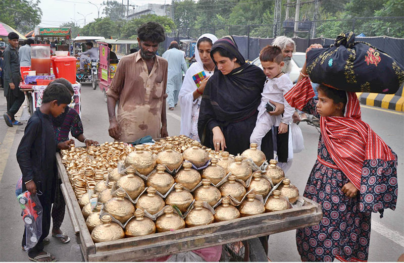 Women and children are busy in purchasing traditional money boxes from vendor near Bibi Pak Daman.