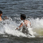 Youngsters taking bath in Arabian Sea to get some relief from hot weather near Native Jetty Bridge.