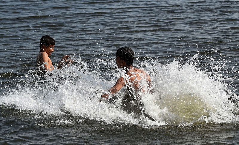 Youngsters taking bath in Arabian Sea to get some relief from hot weather near Native Jetty Bridge.