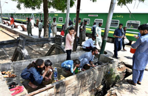 Passengers washing their hands and face at railway station to get relief from hot weather in the city. 