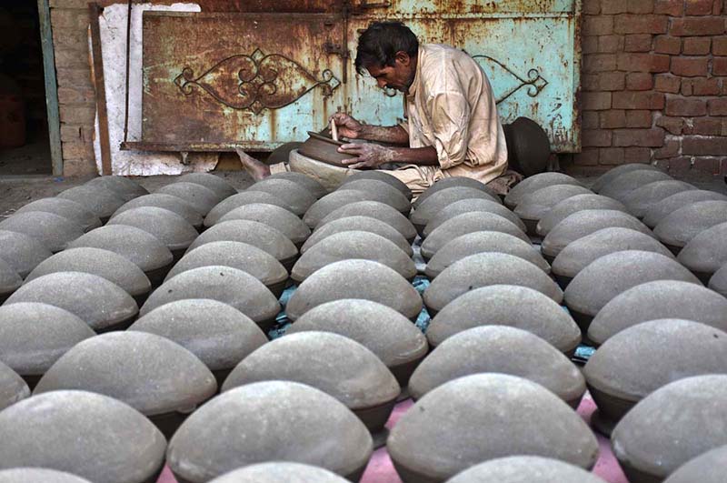 A craftsman preparing clay-made pots at his workplace