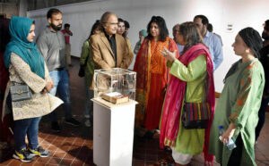 Visitors looking different art work during Exhibition organized by National College of Arts.