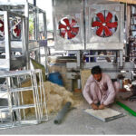 A worker busy in preparing “Khas” for air room-coolers at his roadside workplace.