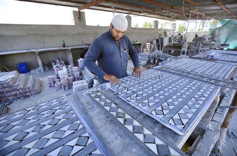 A worker busy in making marble tiles at his workplace near Warsak Road.