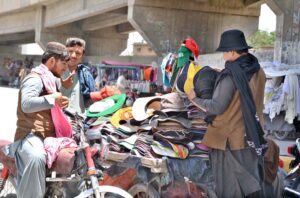 Motorcyclist buying cap at a roadside vendor’s setup in view of hot weather at Joint Road.