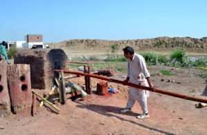 A worker straightening and dyeing bamboos in the hot furnace of a local plant.