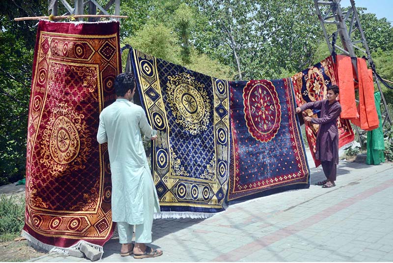 Vendors display carpets at their road side setup to attract the customers.