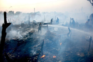 Firefighters struggling to extinguish fire erupted in makeshift huts at Qasimabad.