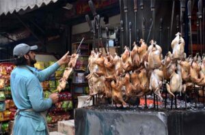 A worker busy in preparing traditional food item “sajji” to attract the customers outside restaurant.