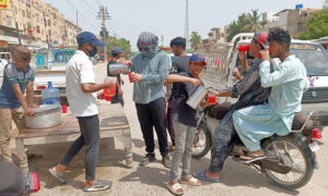 Volunteers giving Juice to People at road side to get relief during extreme hot weather in the city.