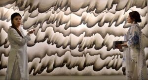 Visitors keenly viewing art work during an exhibition featuring a joint creative interpretation of Iqbal’s Urdu and Persian poetry “…tar-e-harir-e do rang” by artists Shah Abdullah Alamee and Amna Manzoor at Tanzara Art Gallery.