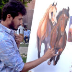 Art student giving final touch to his painting at Alhamra Academy of Performing Arts.