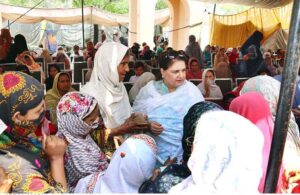 Chairperson Benazir Income Support Programme Mrs. Rubina Khalid, under her supervision, witnessing the payment process to an elderly woman beneficiary at a payment campsite.