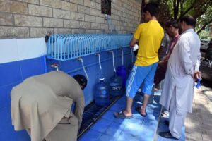 People are filling their pots with clean water at the local water filter plant in Federal Capital