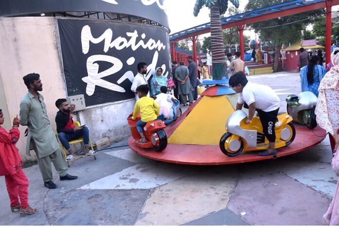 Children enjoy motion ride while celebrating the last day of Eid ul Azha holidays in Allama Iqbal Park, Murree Road