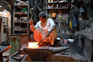 A blacksmith busy in preparing knives to be used for slaughtering sacrificial animals during upcoming Eid ul Azha.