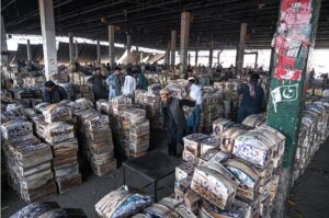 Vendors busy in checking the mangoes filled in wooden boxes before buying at Islamabad Fruit and Vegetable Market.