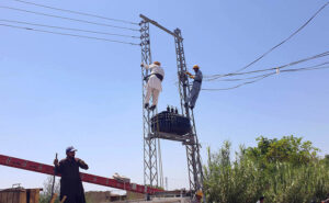 WAPDA workers busy in installing a new transformer at a pylon at Ghouri Town.