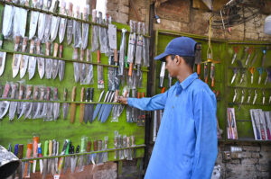 A vendor displaying knives at his shop to be used during sacrificing animals on the eve of Eid-ul Azha.