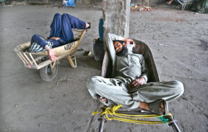 Vendors busy in checking the mangoes filled in wooden boxes before buying at Islamabad Fruit and Vegetable Market.