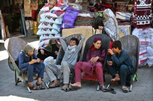 A group of young labourers sitting in handcart waiting for customers to shift luggage in weekly Sunday Bazaar, H-9 Sector.