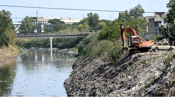Worker busy cleaning garbage with the help of machine from ‘Nullah Lai’ before monsoon season