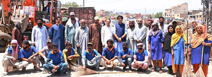 Chairman Rawalpindi Waste Management Company, Saqib Rafeeque in a group photo with the workers during the waste deposit operation on the eve of Eid ul Adha