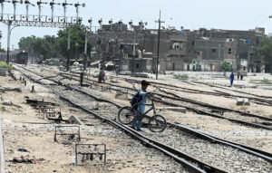 A youngster's risky crossing near the railway station while the train is coming, urging attention from authorities.