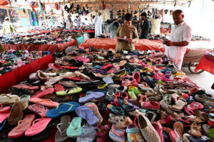 Vendor displaying slippers and sandals to attract the customer at Makki Shah road