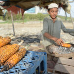 A young vendor preparing corn cob at Seaview
