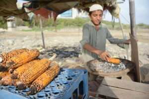 A young vendor preparing corn cob at Seaview