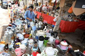Vendor displaying slippers and sandals to attract the customer at Makki Shah road