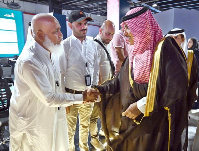 Saudi Minister of Information Salman Al-Dosari shaking hands with foreign journalists during a visit to the media hub established for Hajj 2024