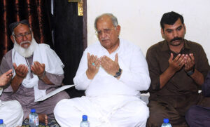 Federal Minister for Housing and Works, Mian Riaz Hussain Pirzada, giving a letter from the Prime Minister to the father of Shaheed Sepoy Asad Ullah at his residence