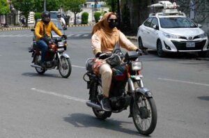 A woman on the way while riding motorcycle as motorcycles provide women with a convenient and affordable mode of transportation.