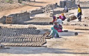 Under the harsh sun,Labourer family molding for a raw bricks at a local kiln in the outskirts area of the city