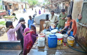 People fill their water cans with clean water from a pipeline for domestic use at Makrani Para.