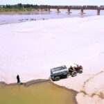 Driver filling their water tanker at Indus river during scorching heat in the city