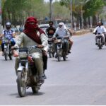 A motorcyclist covered his head and face to protect himself from scorching heat at Cantt Cemetery Road