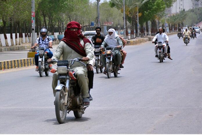 A motorcyclist covered his head and face to protect himself from scorching heat at Cantt Cemetery Road