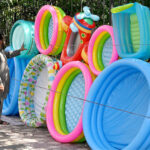 Vendor selling and displaying inflatable swimming pools to attract the customers at roadside setup