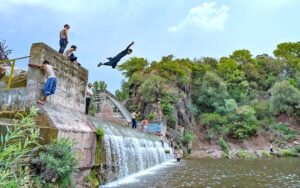 Youngsters jump into a stream of water to beat the heat at Angoori during a extreme hot weather