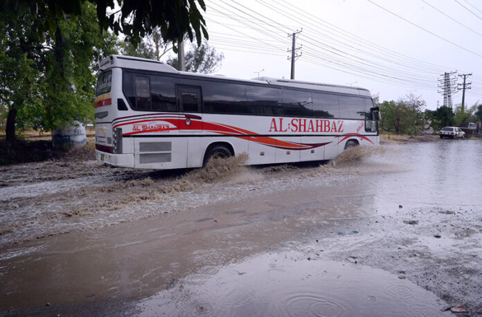 Vehicles passing through stagnant rain water accumulated on road during heavy rain that experienced in Federal Capital