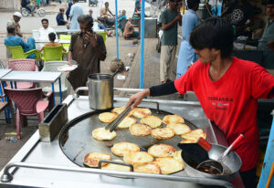 A worker busy in preparing the traditional bread ‘parathas’ for the customers at local hotel.