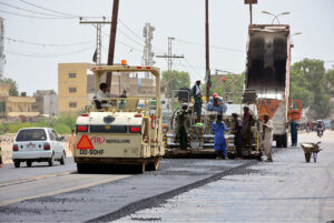 Labourers busy in preparing the new carpeting of kotri area road with help of machine during development work in the city