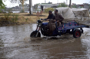 Vehicles passing through stagnant rain water accumulated on road during heavy rain that experienced in Federal Capital